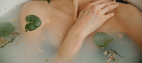 woman‘s hand resting on her chest in a herbal bath.